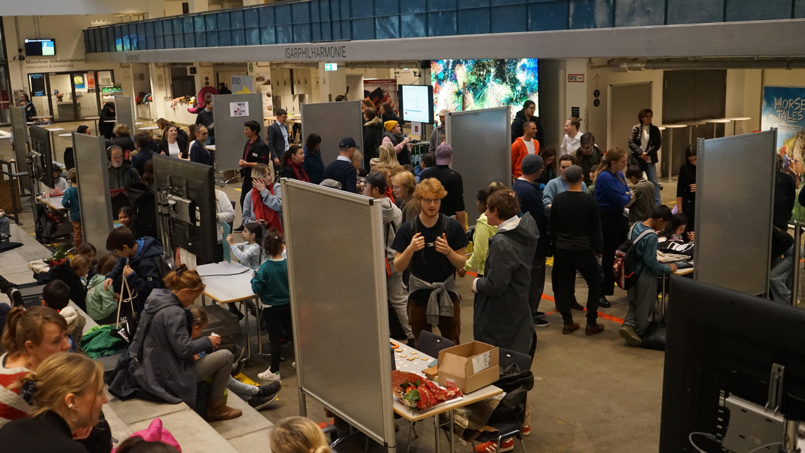 Ein Blick in das Foyer der Halle E. Viele Erwachsene und Kinder tummeln sich an unterschiedlichen Ständen.