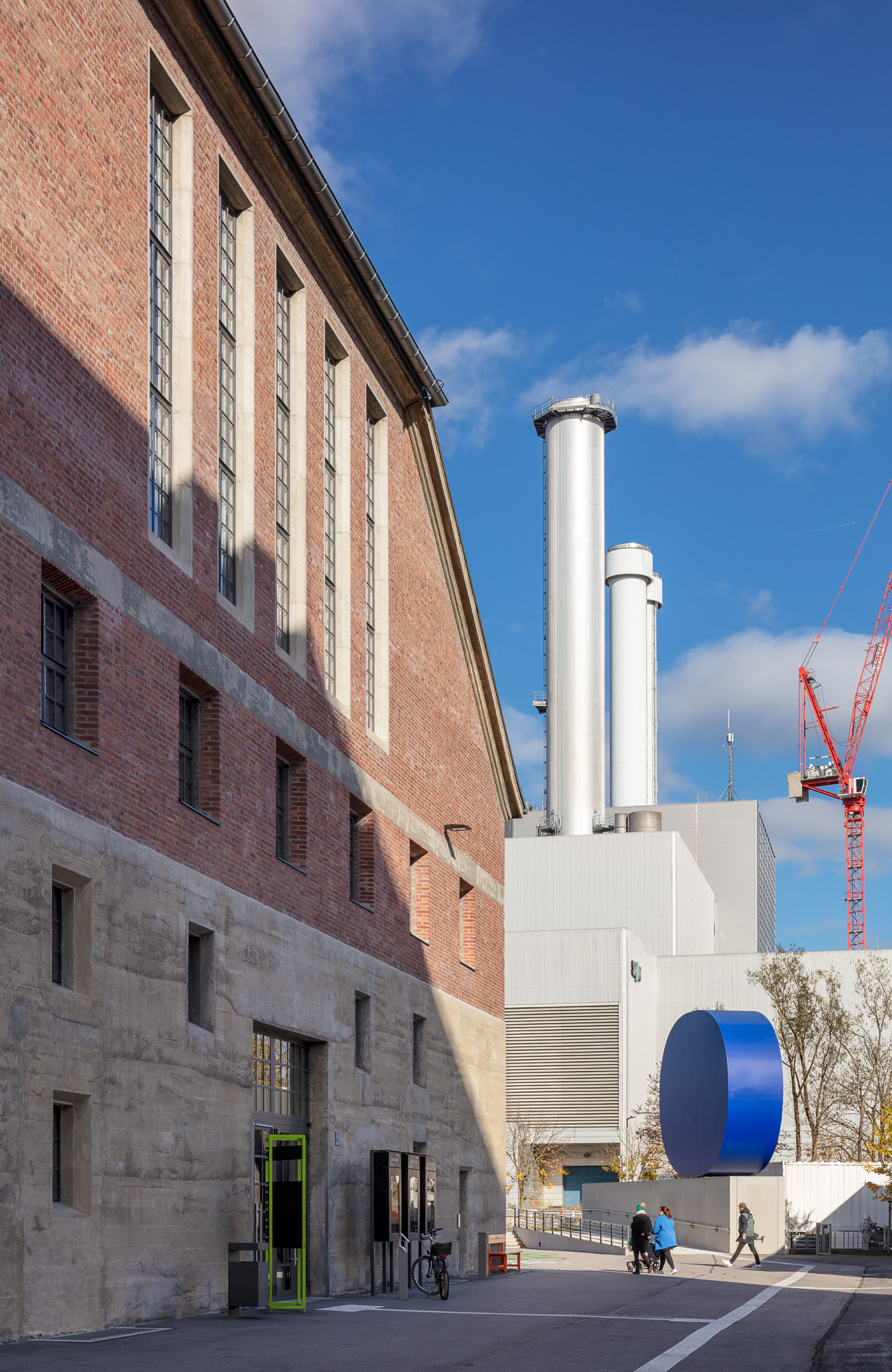 Die Backsteinhalle Halle E von außen, der Blick geht zu den Türmen des Heizkarftwerks gegenüber. 