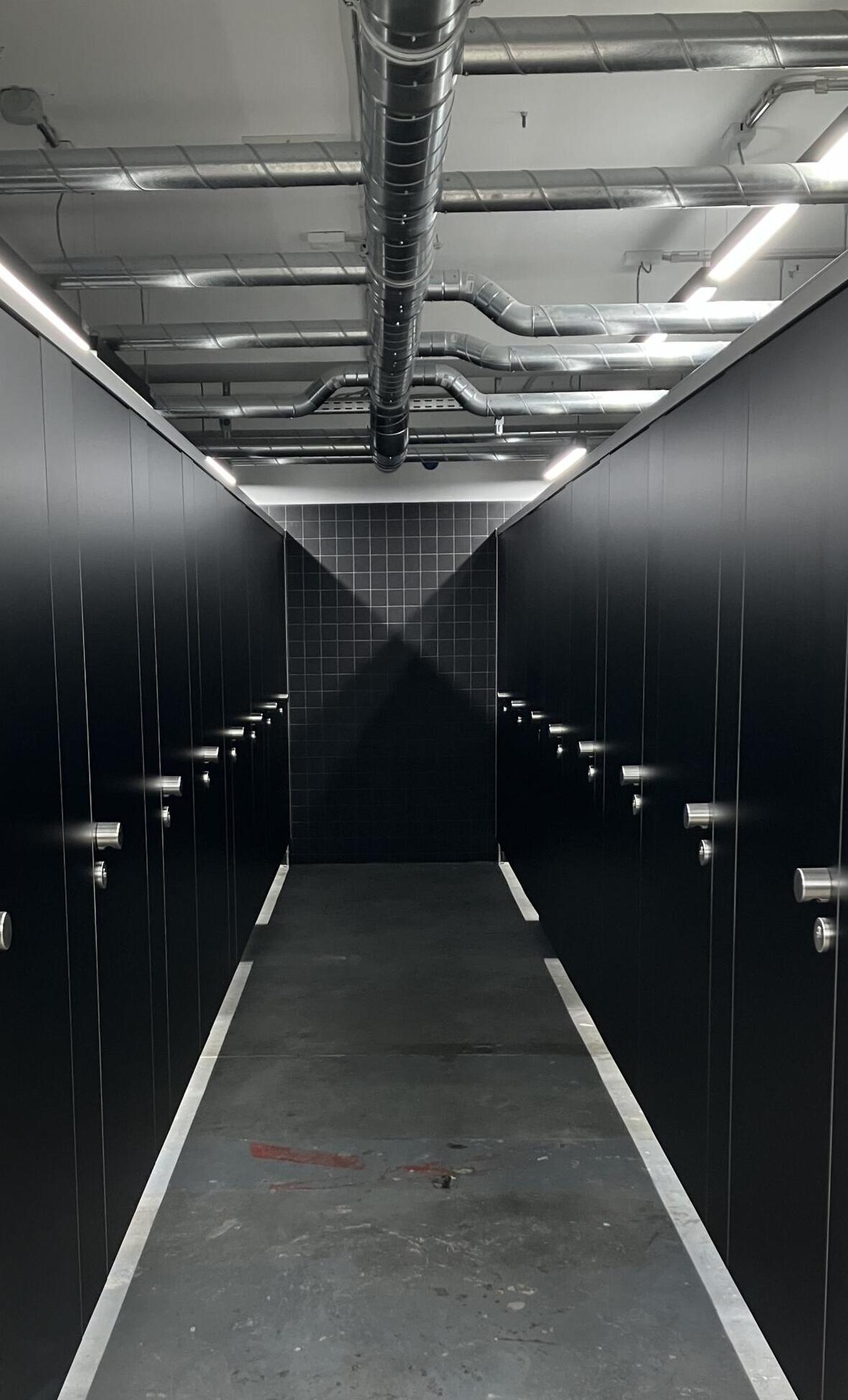 A corridor with black doors on the right and left.